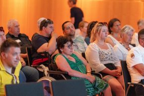 Man sieht das Publikum. Die Teilnehmerinnen und Teilnehmer schauen konzentriert in Richtung Bühne.