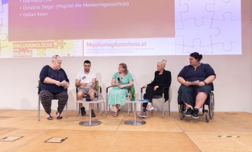 direkter Blick auf das Podium auf dem Moderatorin Iris Kopera, Volkan Aslan, Eva-Maria Fink und Christine Steger und Yuria Knoll sitzen