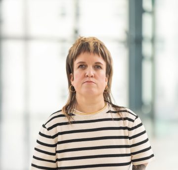 Frau mit Vokuhila und gestreiftem Shirt