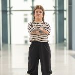 Kleinwüchsige Frau mit Vokuhila und gestreiftem Shirt verschränkt die Arme