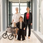 3 Frauen stehen als Dreieck zusammen und schauen ernst in die Kamera